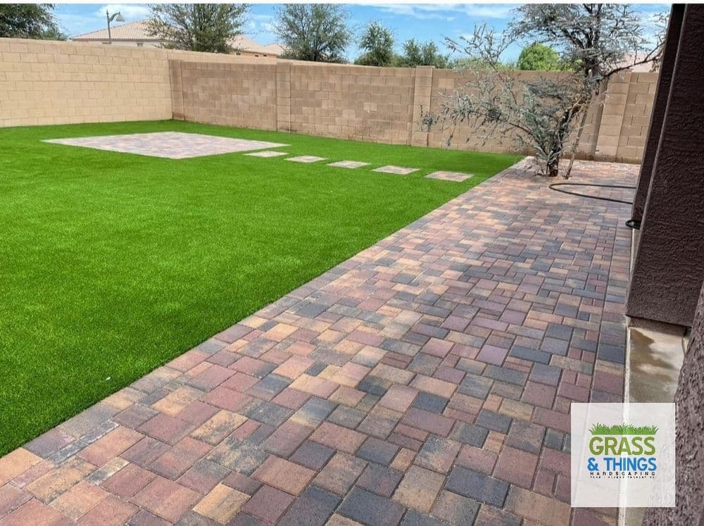 Lush green lawn and brick patio in a well-designed backyard landscape.