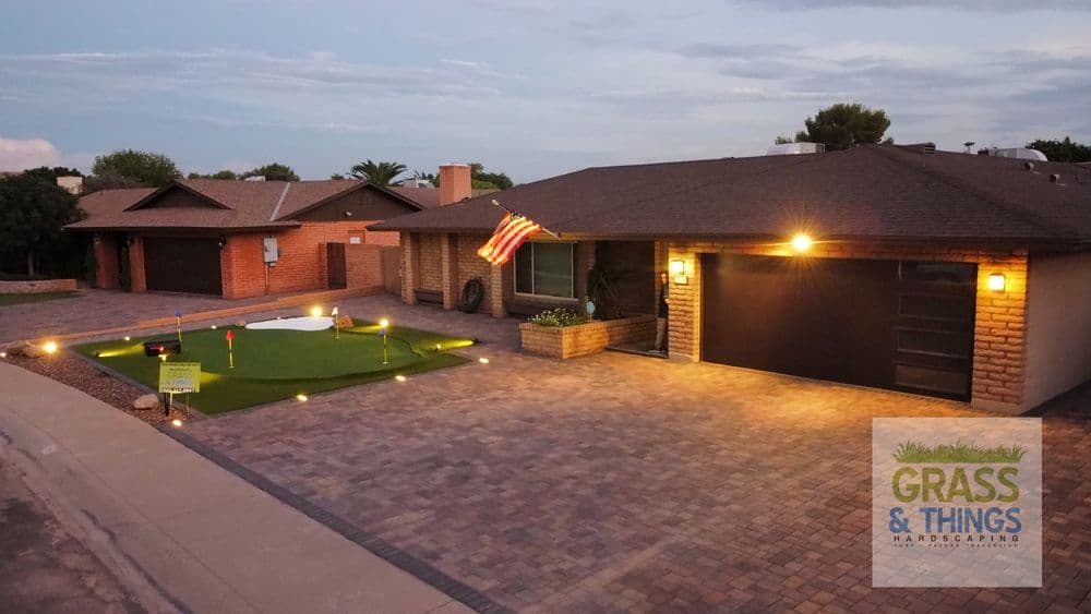 Residential home with a festive American flag and a landscaped yard featuring a putting green.