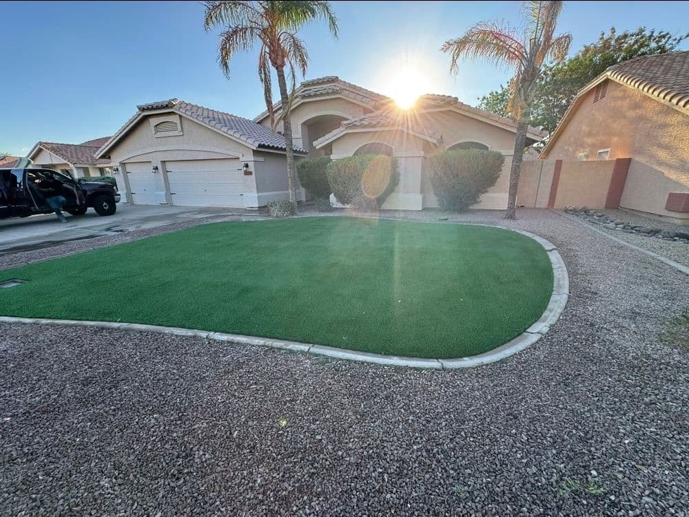 Sunlit front yard with artificial turf and palm trees in a suburban neighborhood.